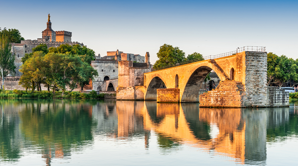 arched bridge over water with a picturesque town stretching beyond